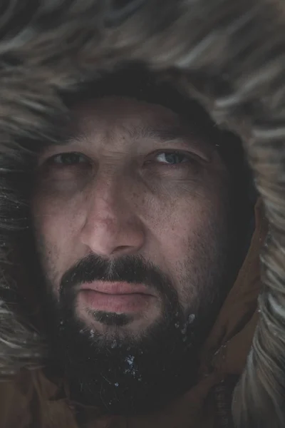 Hombre en invierno en clima tormentoso usando abrigo de piel caliente — Foto de Stock