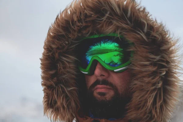 Man in de winter bij stormachtig weer draagt warme bontjas — Stockfoto