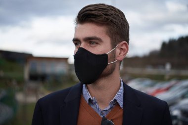 Lüks ofiste koruyucu yüz maskesi takan bir iş adamı.