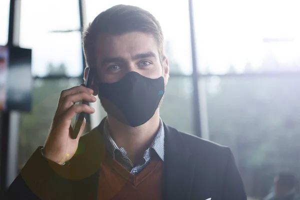 Uomo d'affari indossa coronavirus maschera medica durante l'utilizzo di smartphone — Foto Stock