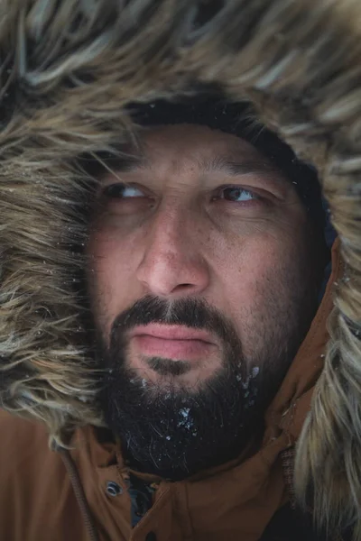 Man in de winter bij stormachtig weer draagt warme bontjas — Stockfoto