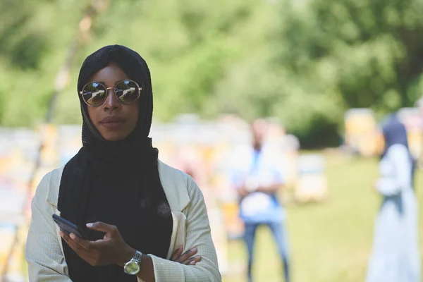 Afryki kobieta za pomocą smartfona w tradycyjne islamskie ubrania — Zdjęcie stockowe