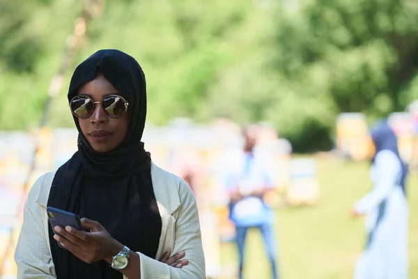 ผู้หญิงชาวแอฟริกันใช้สมาร์ทโฟนสวมเสื้อผ้าอิสลามแบบดั้งเดิม — ภาพถ่ายสต็อก