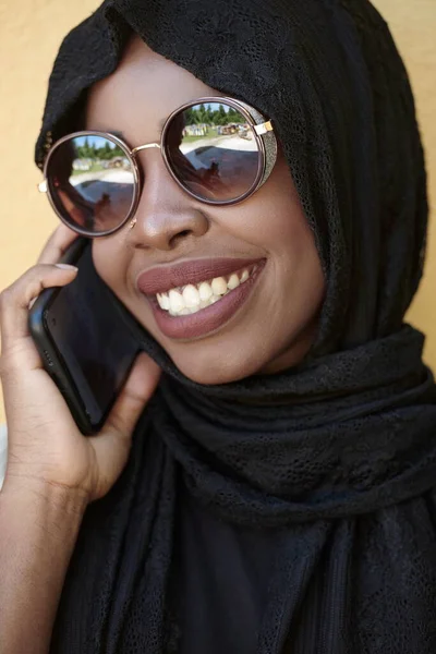Afryki kobieta za pomocą smartfona w tradycyjne islamskie ubrania — Zdjęcie stockowe