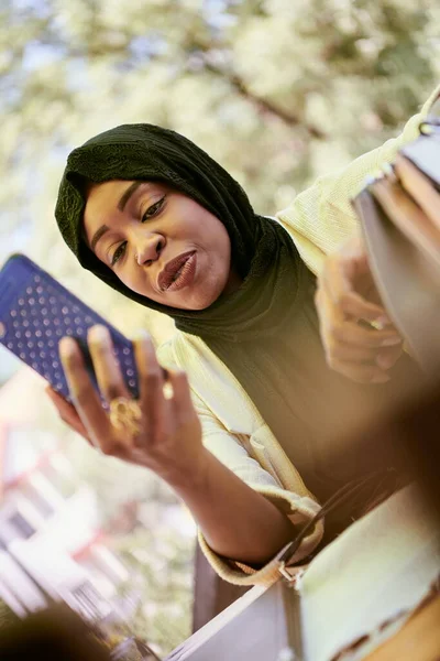 Mulher africana usando smartphone vestindo roupas islâmicas tradicionais — Fotografia de Stock