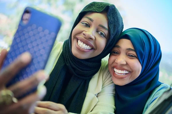 Afrikanska kvinnliga vänner som använder smarttelefon tillsammans — Stockfoto