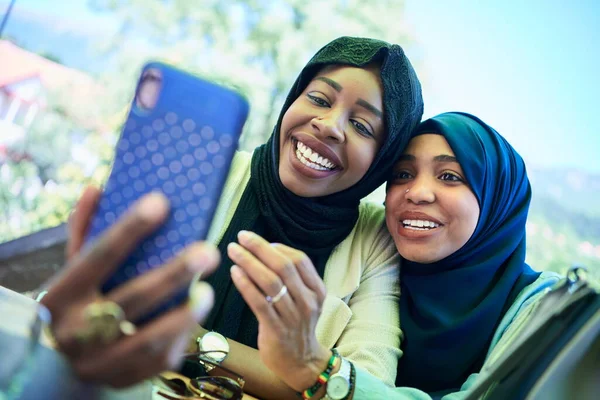 Африканские подруги используют смартфон вместе — стоковое фото