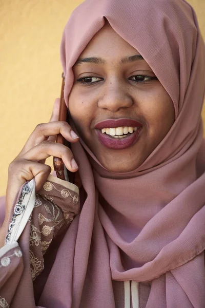 ผู้หญิงชาวแอฟริกันใช้สมาร์ทโฟนสวมเสื้อผ้าอิสลามแบบดั้งเดิม — ภาพถ่ายสต็อก