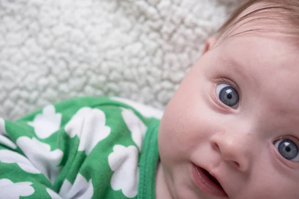 Pequeno bebê bonito brincando com as mãos e sorrindo — Fotografia de Stock