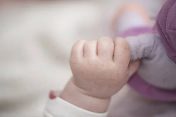 Pequeno bebê bonito brincando com as mãos e sorrindo — Fotografia de Stock