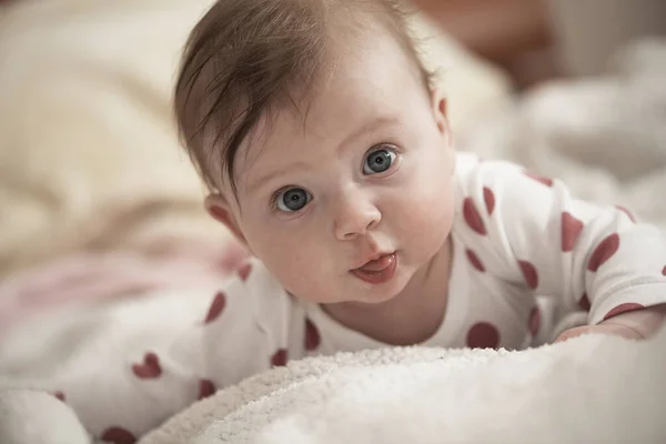 Pequeno bebê bonito brincando com as mãos e sorrindo — Fotografia de Stock