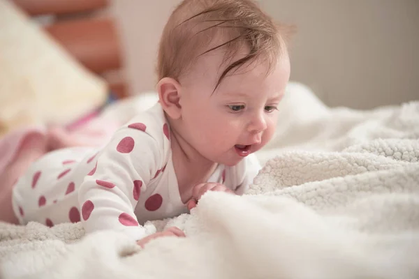 Aranyos kis baba játszik a kezét és mosolyog — Stock Fotó