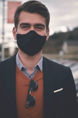 Lüks ofiste koruyucu yüz maskesi takan bir iş adamı.