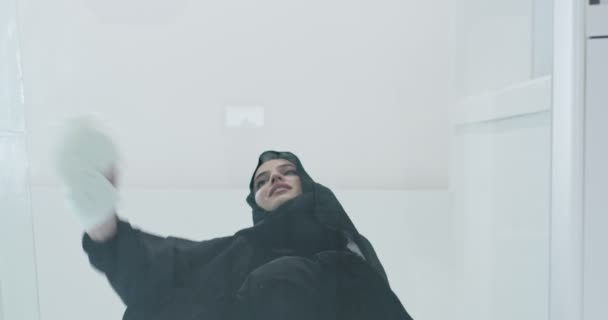 Joven musulmana árabe vestida con ropa tradicional de hiyab rezando en el suelo de cristal — Vídeos de Stock