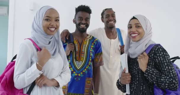 Gruppenporträt glücklicher afrikanischer Studenten, die zusammen vor weißen Mädchen stehen, die traditionelle sudanesische muslimische Hijab-Mode tragen — Stockvideo