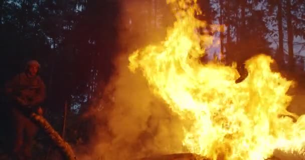 Operarios militares en acción y saltando sobre el fuego en el denso bosque por la noche, concepto de acción del ejército por la noche — Vídeos de Stock