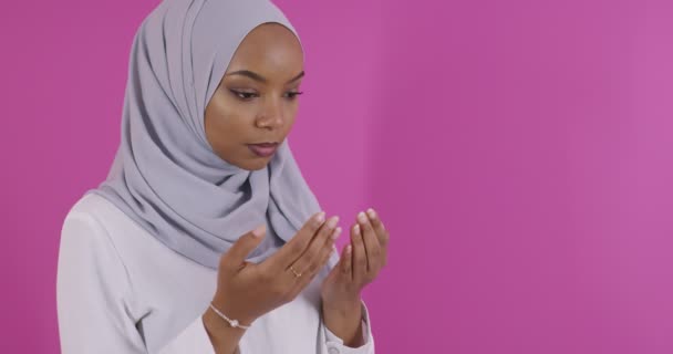 Modern afrikansk Muselman kvinna gör traditionell bön till Gud över färgglada bakgrund — Stockvideo
