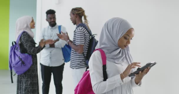 Mahasiswa musilm dengan kelompok teman-teman di latar belakang mengenakan pakaian tradisional jilbab Islam dan menggunakan tablet — Stok Video