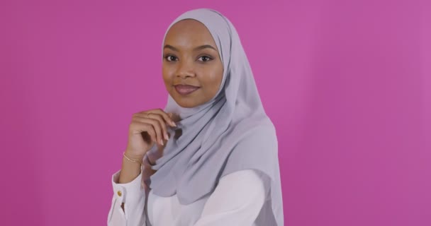 プラスチックピンクの背景に伝統的なイスラム服を着て若い現代のイスラム教徒アフロの美しさの肖像画 — ストック動画