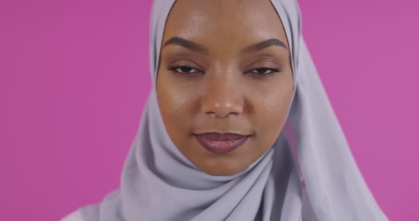 Közelkép fiatal modern muszlim afro szépség visel hagyományos iszlám ruhák műanyag rózsaszín háttér — Stock videók