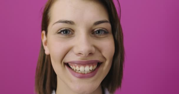 Jeune femme sur fond rose isolé souriant et s'amusant — Video