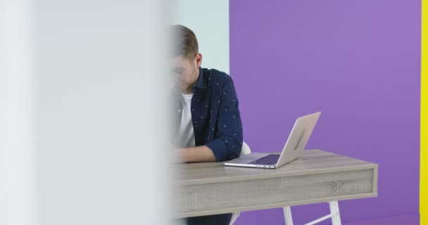Красивий молодий чоловік використовує ноутбук в сучасному офісі, фрілансер, який працює вдома новий проект — стокове відео