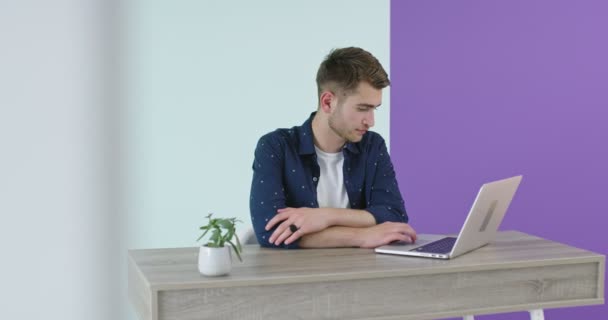 Schöner junger Mann mit Laptop in einem modernen Büro, Freiberufler arbeitet zu Hause neues Projekt — Stockvideo