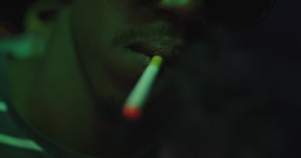 アフリカ系アメリカ人の男性はネオンを背景に都市の照明でパーティー飲みや喫煙をしている — ストック動画