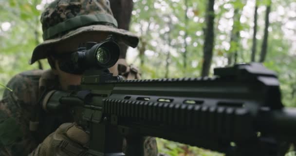 Plně vybavený střelecký voják v maskovací uniformě útočící na nepřítele, puška v palebné pozici v hustém lese — Stock video