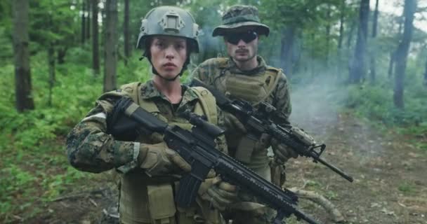 Orman bölgesinde devriye gezen bir grup asker. Yoğun ormanda erkek ve kadın askerlerle birlikte. Sırtında dumanla. — Stok video