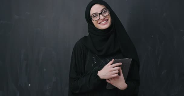 Jong modern moslim zakenvrouw houden tablet computer dragen hijab kleding in de voorkant van zwart schoolbord — Stockvideo
