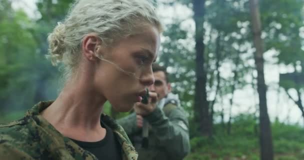 Terrorister med vapen tillfångatagna kvinna soldat gisslan i tät skog med rök i backgorund — Stockvideo