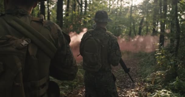 Sekelompok tentara bergerak melalui hutan asap dengan senapan siap untuk menembak, berjalan melalui hutan selama aksi militer — Stok Video