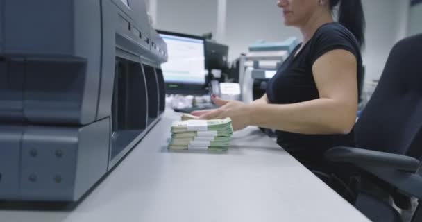 Menschen, Finanzen und Bargeldkonzept - Sachbearbeiter, der Dollars mit elektronischem Geldzähler an Bankschaltern oder Geldwechselautomaten zählt — Stockvideo