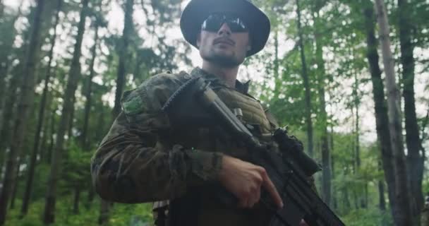 Moderner Soldat mit Gewehr im Wald mit Rauch im Hintergrund — Stockvideo