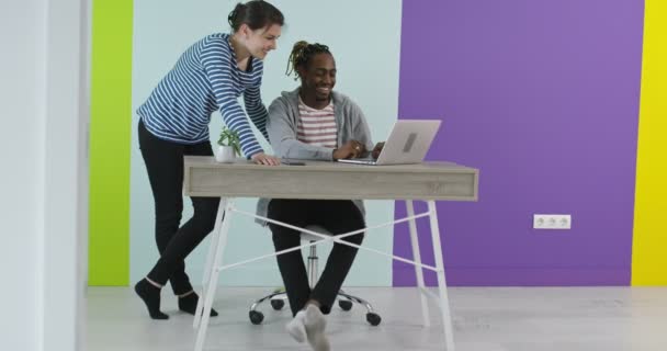 Позитивний усміхнений чоловік і жінка біля робочого місця з ноутбуком, що співпрацює в офісі — стокове відео
