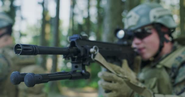 숲 속 의군 기지를 보호하면서 돌격소총을 사용하는 고형물의 근접 사진 — 비디오