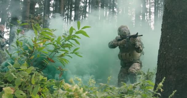 Солдати ведуть воєнні дії в густому лісі з димом у зворотному напрямку, армія проводить дії в лісі — стокове відео