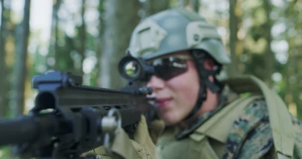 숲 속 의군 기지를 보호하면서 돌격소총을 사용하는 고형물의 근접 사진 — 비디오