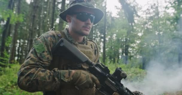 Soldat tirant au fusil dans la forêt, fumée en arrière-plan, concept militaire et militaire — Video