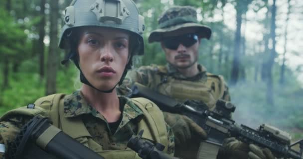 Oddíl vojáků hlídkujících přes les, tým s mužskými a ženskými vojáky v hustém lese s kouřem v pozadí — Stock video