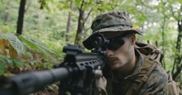 완벽 한 장비를 갖춘 소총 병, 위장 제복을 입고 적군을 공격하는 모습, 빽빽 한 숲에서 사격 위치에 있는 소총 — 비디오
