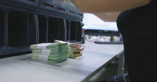 人、金融、現金の概念-銀行のオフィスや通貨交換機で電子マネーカウンターマシンでドルを数える事務員の手 — ストック動画