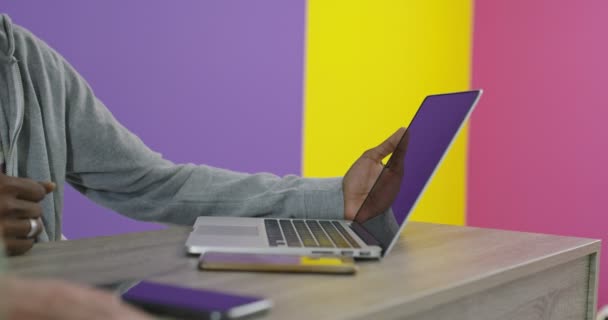 Homem e mulher sorridentes positivos perto do local de trabalho com laptop cooperando no escritório — Vídeo de Stock