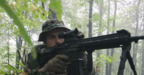 Soldato fucile completamente equipaggiato con uniforme mimetica che attacca il nemico, fucile in posizione di tiro nella fitta foresta — Video Stock