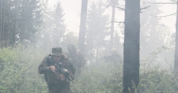 士兵带着准备射击的来复枪穿过烟雾弥漫的森林，在军事行动期间穿过森林 — 图库视频影像