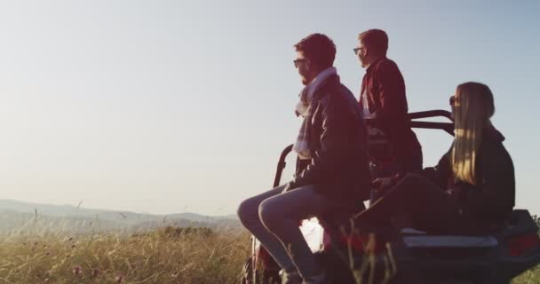 Młodzi przyjaciele hipsterzy bawiący się w porannym słońcu, hipsterzy szukający przygody na off road car — Wideo stockowe