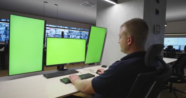 Spezialist für Systemsicherheit arbeitet im System Control Center. Der Raum ist voll von grünen Bildschirmen, Chroma-Bildschirm und Sicherheit — Stockvideo