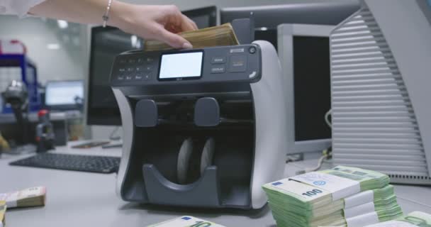Mensen, financiën en cash concept - klerk hand tellen dollars met elektronisch geld teller machine bij bank kantoor of wisselaar — Stockvideo