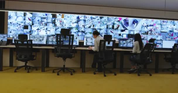 Φρουροί ασφαλείας παρακολουθούν σύγχρονες κάμερες CCTV στο δωμάτιο παρακολούθησης — Αρχείο Βίντεο